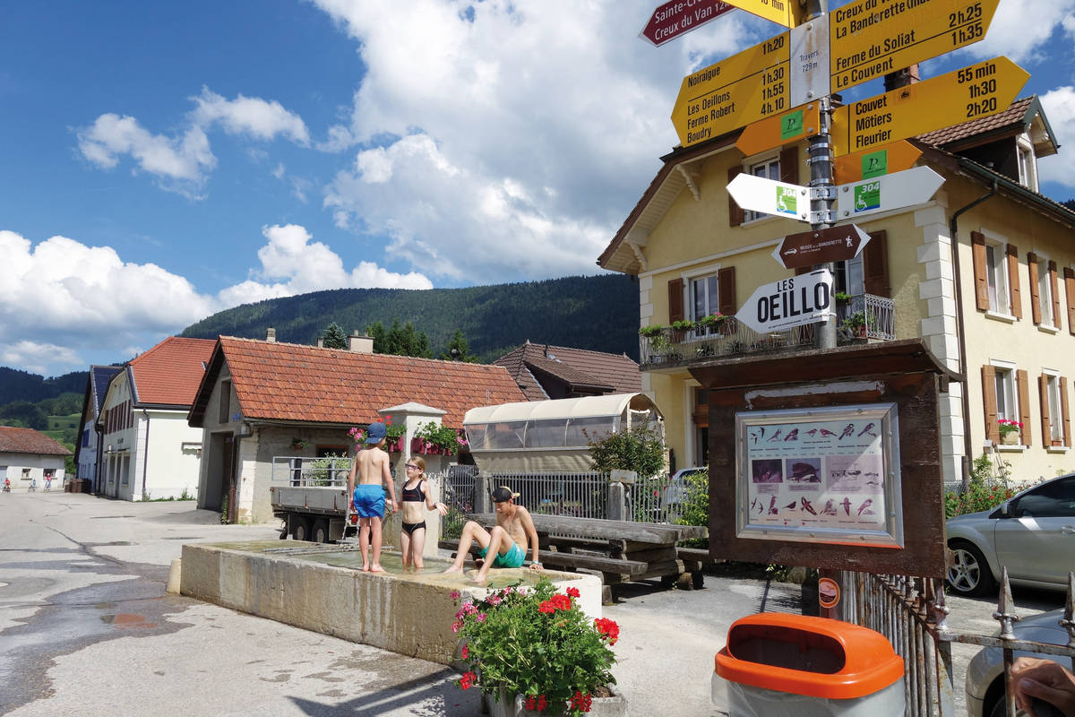 In Travers ist es ruhig, viele Einwohner sind weggezogen – beim Dorfbrunnen aber herrscht Leben, wo Kinder vergnüglich plantschen.