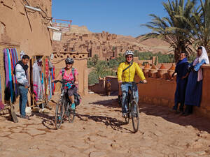 Fahrt durch den neuen Teil der Stadt Ait Benhaddou; die alte Stadt ist im Hintergrund zu sehen und zugleich UNESCO-Weltkulturerbe.