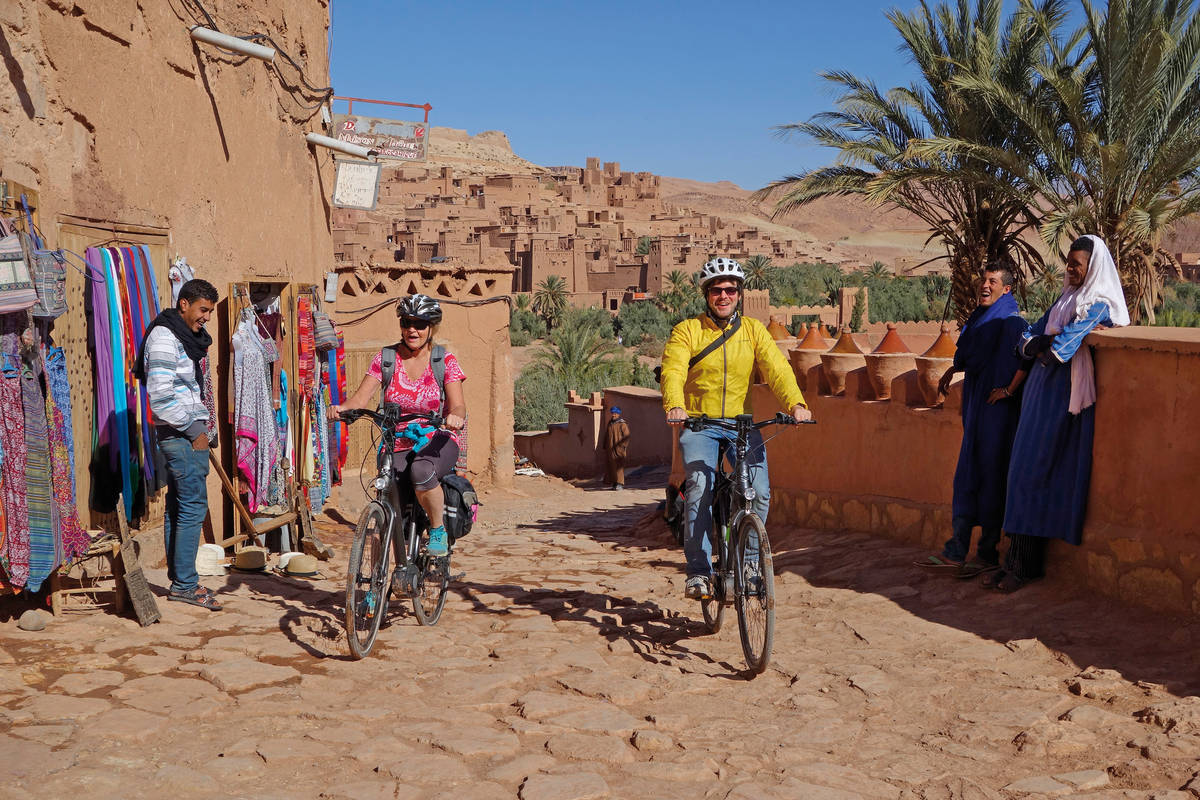 Fahrt durch den neuen Teil der Stadt Ait Benhaddou; die alte Stadt ist im Hintergrund zu sehen und zugleich UNESCO-Weltkulturerbe.